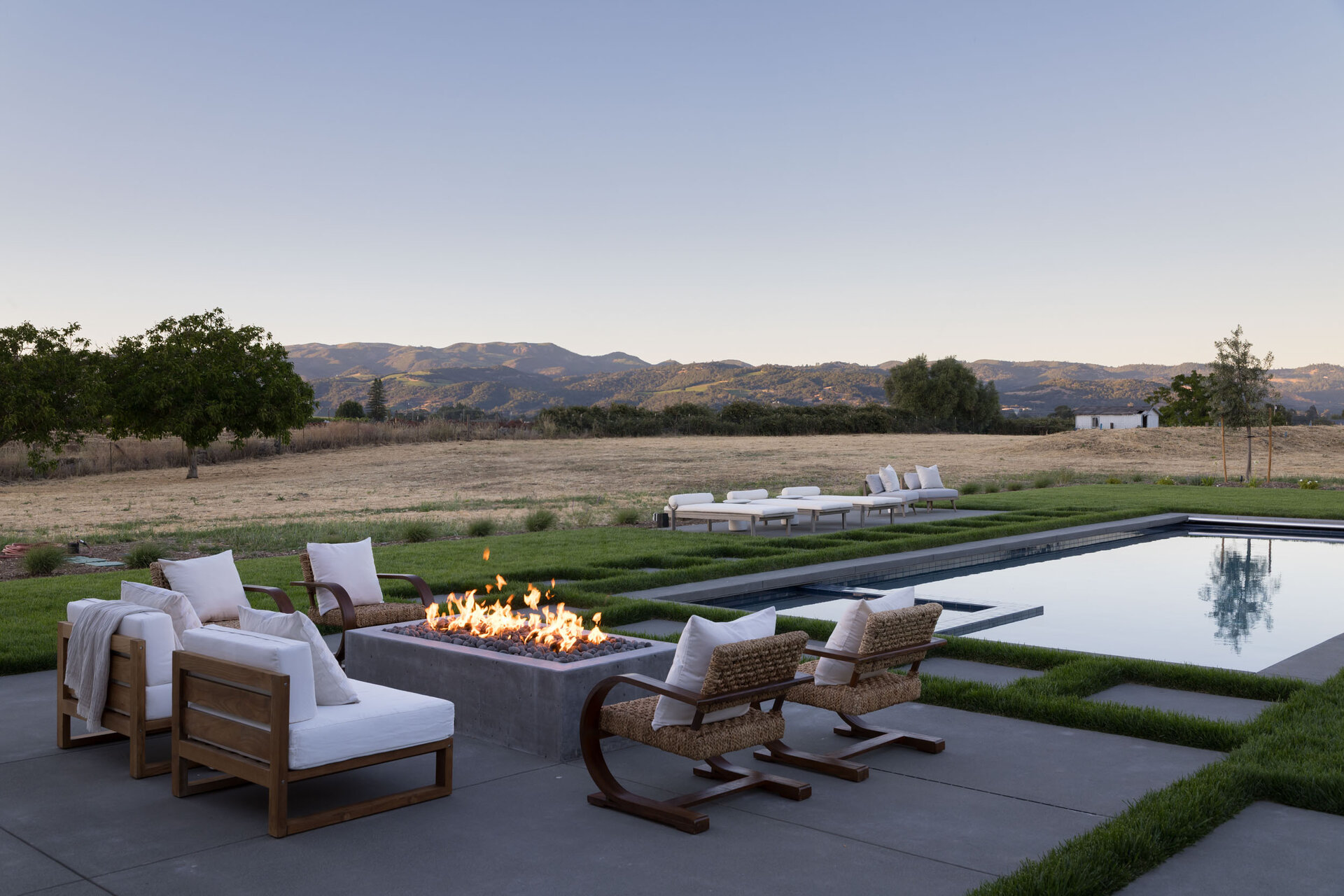 Fire pit and pool terrace at twilight, set for gathering