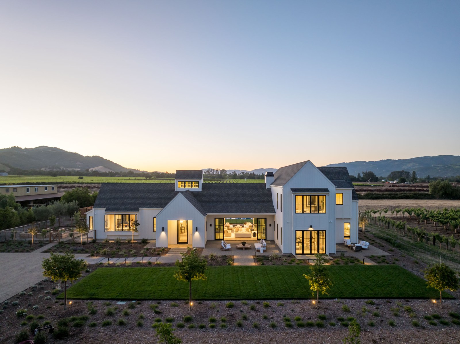 Twilight view of the estate with vineyards and hills beyond